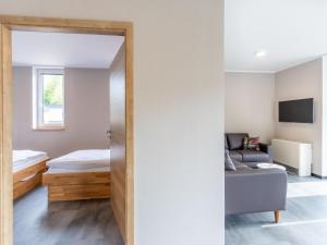a room with a bed and a couch and a mirror at Kronenburger Comfort Bungalow in Hallschlag
