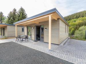 un edificio con un patio con mesa y sillas en Inviting bungalow in Hallschlag with terrace, en Hallschlag