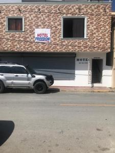 a white suv parked in front of a hotel at Hotel Freedom Nagua in Nagua