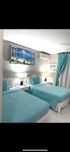 Ocho Rios Vacation Resort Property Rentals في أوتشو ريوس: سريرين في غرفة الفندق ذات شراشف زرقاء