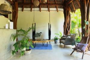 a living room with a table and some plants at Tierra Mia Boutique Hotel in Holbox Island