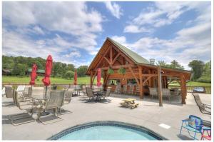 a pavilion with a table and chairs and a pool at High N Dry-Quiet River Access Neighborhood, 1 Mile to Parkway, 5 Miles to Dollywood! in Pigeon Forge