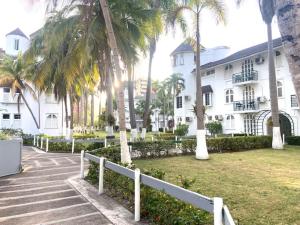 un edificio blanco con palmeras delante en Ocho Rios Vacation Resort Property Rentals, en Ocho Ríos