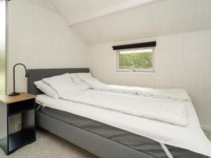 een bed in een kleine kamer met een raam bij Holiday home Græsted XI in Græsted