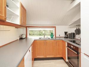 een keuken met houten kasten en een raam bij Holiday home Græsted XI in Græsted