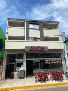 un restaurante con mesas rojas y sillas frente a él en Complejo Aires 3 en San Bernardo