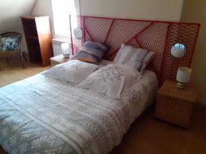 a bedroom with a large bed with a red headboard at Gîte Louchy-Montfand, 3 pièces, 4 personnes - FR-1-489-178 in Louchy-Montfand