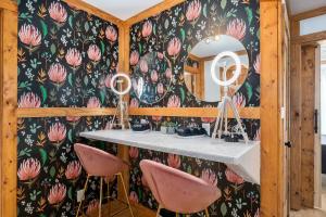 ein Raum mit einem Tisch mit rosa Blumen an einer Wand in der Unterkunft Hollmig Haus - Sleeps 12 with Hot Tub & Beauty Bar in Fredericksburg + 50 Fotos