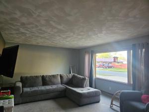 a living room with a couch and a large window at Entire home 5min to Senior Open+Breakfast! in Stevens Point