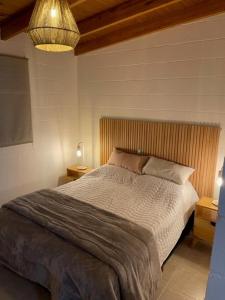 een slaapkamer met een groot bed en een lamp bij Cómodo depto en Comodoro Rivadavia! in Comodoro Rivadavia