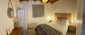 een kleine slaapkamer met een bed en een spiegel bij Cómodo depto en Comodoro Rivadavia! in Comodoro Rivadavia
