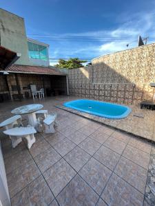 einen Hinterhof mit einem Pool, einem Tisch und einer Bank in der Unterkunft Casa em Penha sc in Penha