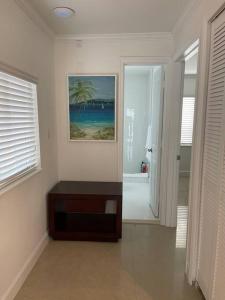 uma sala de estar com uma mesa e um quadro na parede em Villa Capri Cottage in the heart of Miami em Miami