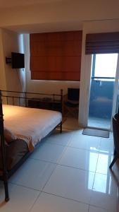 Schlafzimmer mit einem Bett und einer Glasschiebetür in der Unterkunft Studio Suite Roseville @ BSD City, Great Location in Tangerang