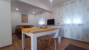 a white dining room with a table and chairs at Mondalva Apartamentos in São Pedro de Alva