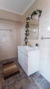 a bathroom with a white sink and a mirror at Mondalva Apartamentos in São Pedro de Alva