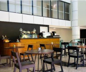 a group of tables and chairs in a restaurant at Mediterrâneo Flat in Rio de Janeiro