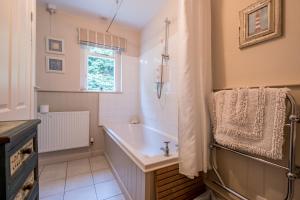 a bathroom with a tub and a sink at Sandy Lodge Rock in Padstow
