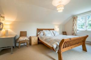 a bedroom with a bed and a bench and a window at Sandy Lodge Rock in Padstow