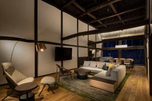 a living room with a couch and a tv at SOMA RESIDENCE HAKUBA in Hakuba