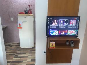 uma televisão e um frigorífico num quarto em Apto Amar - No Espaço Florescer em Campos dos Goytacazes
