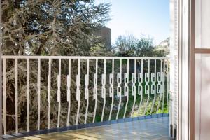 een wit hek op een balkon met bomen bij 114b - Casa Luna Vista Mare, 5 minuti dalla spiaggia a piedi - PARCHEGGIO PRIVATO GRATIS INCLUSO in Ospedaletti
