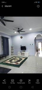 un soggiorno con ventilatore a soffitto e TV di Homestay penghulu noor a Pasir Puteh