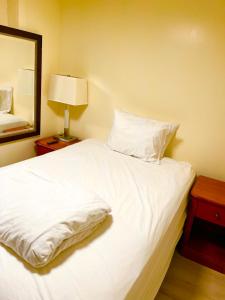 BedExpress في بالتيمور: سرير أبيض في غرفة مع مرآة