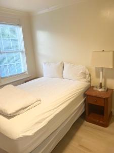 a bed with white sheets and a lamp on a table at BedExpress in Baltimore