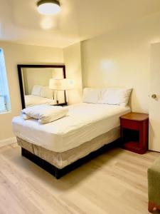 BedExpress في بالتيمور: غرفة نوم مع سرير أبيض كبير مع مرآة