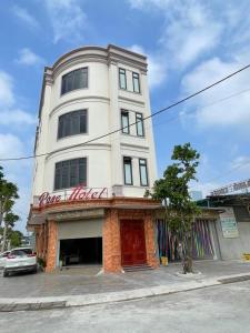 a white building with a red sign on it at Rose hotel 