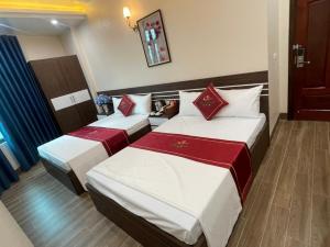 a hotel room with two beds with red and white sheets at Rose hotel 
