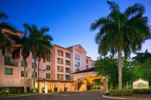 un hotel con palme di fronte a un edificio di Courtyard Fort Lauderdale SW Miramar a Miramar