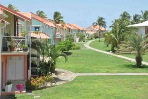 une allée traversant le jardin d'un complexe hôtelier bordée de palmiers dans l'établissement Lullaby of the sea Crystal beach Saint François, à Saint-François