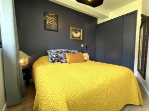 - une chambre avec un lit et une couette jaune dans l'établissement Appartement Bénodet, 2 pièces, 4 personnes - FR-1-481-142, à Bénodet