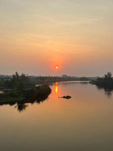 a sunset on a river with the sun setting at Lakeside Homestay in Hoi An