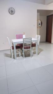 a white dining room table and chairs on a white floor at Roli in Clorinda