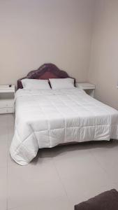 a white bed with white sheets and pillows at Roli in Clorinda
