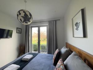 a bedroom with a bed and a large window at Envisage Estate in Cambridge