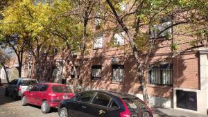 dos coches estacionados frente a un edificio de ladrillo en Departamento 2 Habitaciones en Rosario