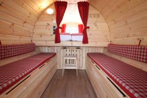 AZUR Camping Wertheim في فيرتهايم: غرفة مع كرسيين حمر في كابينة