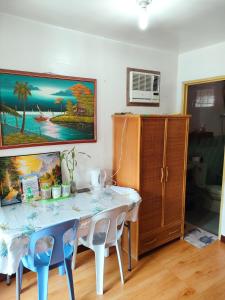 Puerto Galera Transient Kubo Guest Place في بويرتو غاليرا: طاولة غرفة طعام مع كرسيين وخزانة