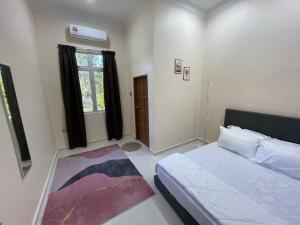 Una cama o camas en una habitación de King's Cottage Homestay Kubang Kerian