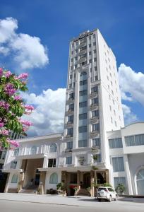 a white building with a car parked in front of it at CityBay Palace Hạ Long Hotel in Ha Long