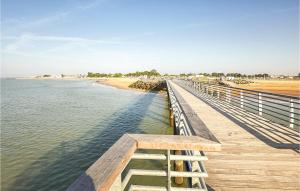 a wooden boardwalk leading to a beach and the water at Stunning Home In La Faute Sur Mer in La Faute-sur-Mer