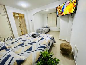 a bedroom with a bed and a flat screen tv at Suite in the exclusive area of San Marino in Guayaquil