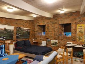 ein Schlafzimmer mit einer Ziegelwand mit einem Bett und Stühlen in der Unterkunft Station im Norden in Bindslev