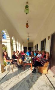 um grupo de pessoas sentadas em cadeiras numa sala em Royal Farm Bharatpur em Bharatpur