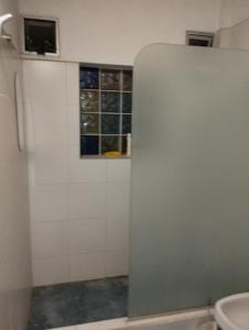 baño con aseo y ventana en La Lechuza hospedaje en Salta