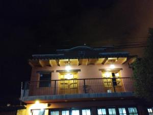 un gran edificio con balcón por la noche en La Lechuza hospedaje en Salta